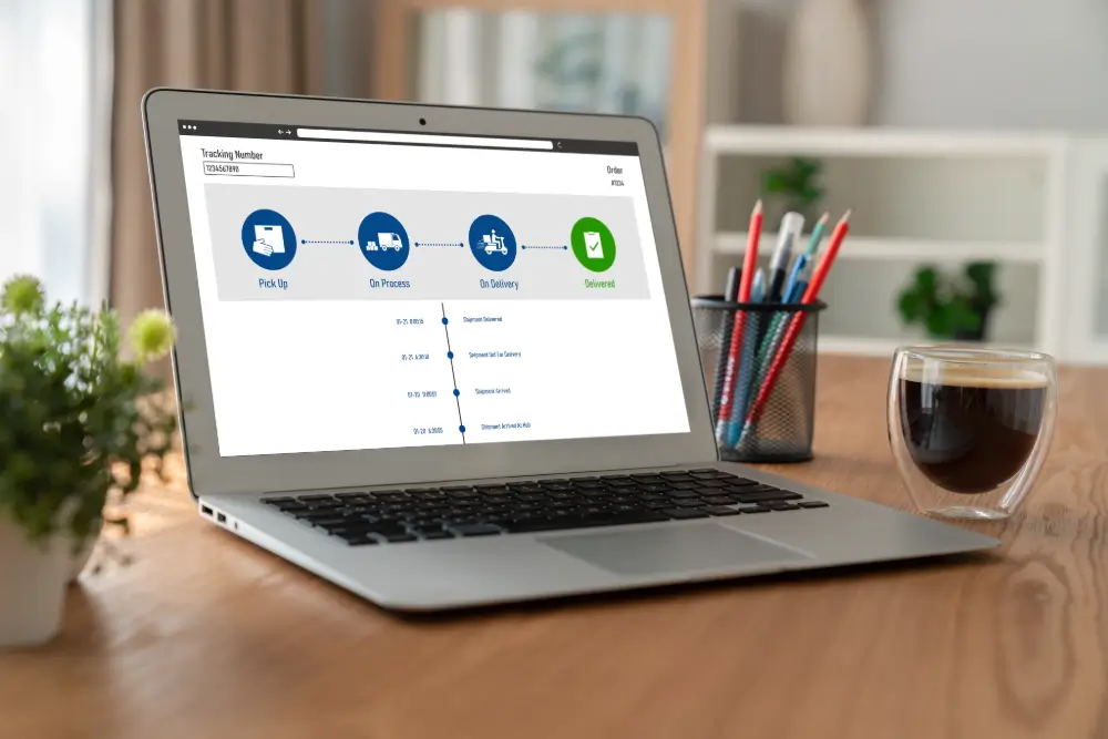 A laptop on a desk showing a parcel tracking page, its progress bar at Delivered