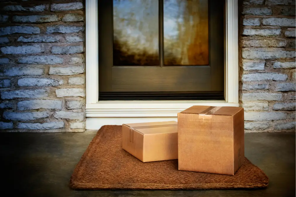 Two cardboard parcels sit unattended on a doormat outside a front door