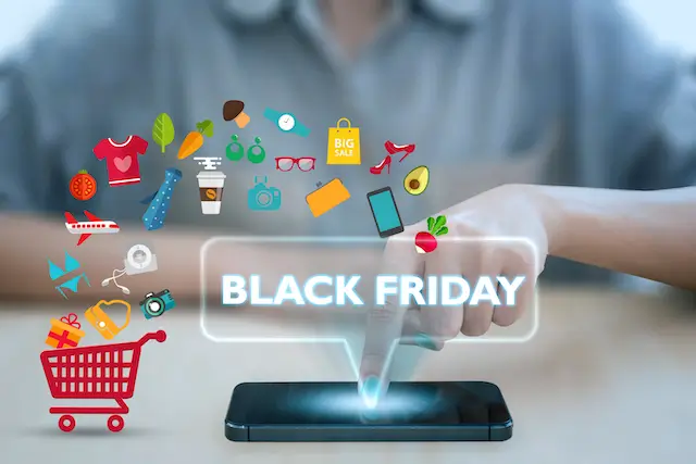 A finger tapping a phone that projects a glowing “Black Friday” sign, surrounded by shopping icons: clothes, groceries, gadgets and a red cart
