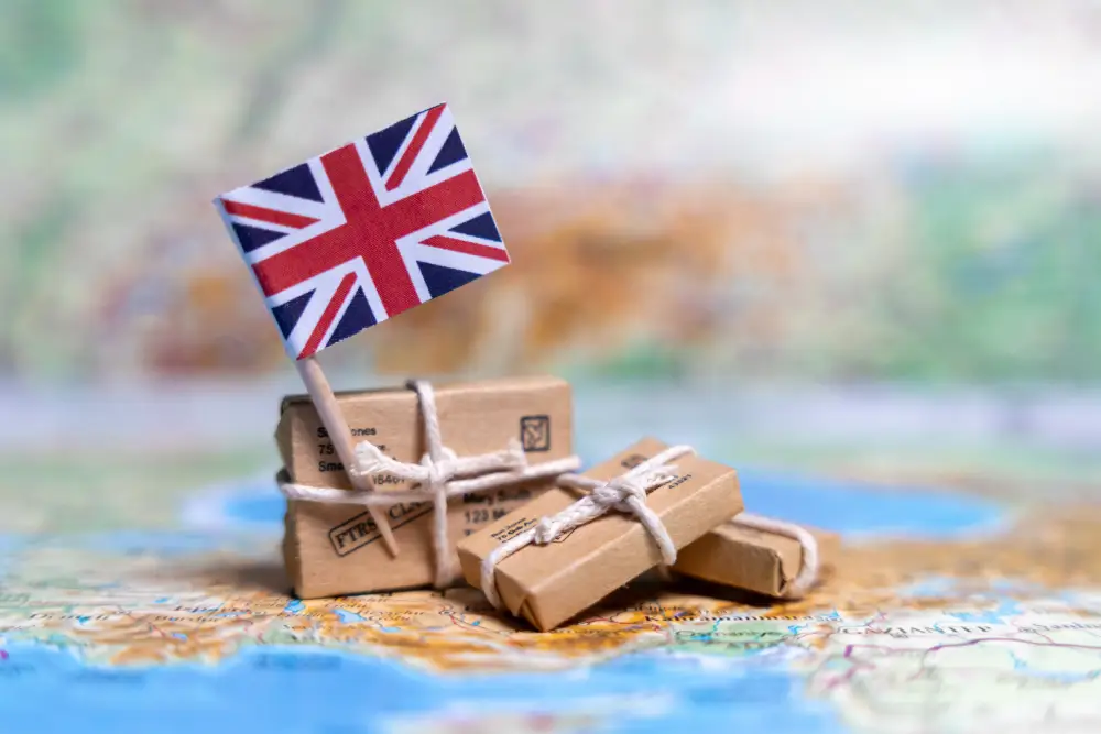 A small British flag planted in a stack of string-tied parcels resting on a map