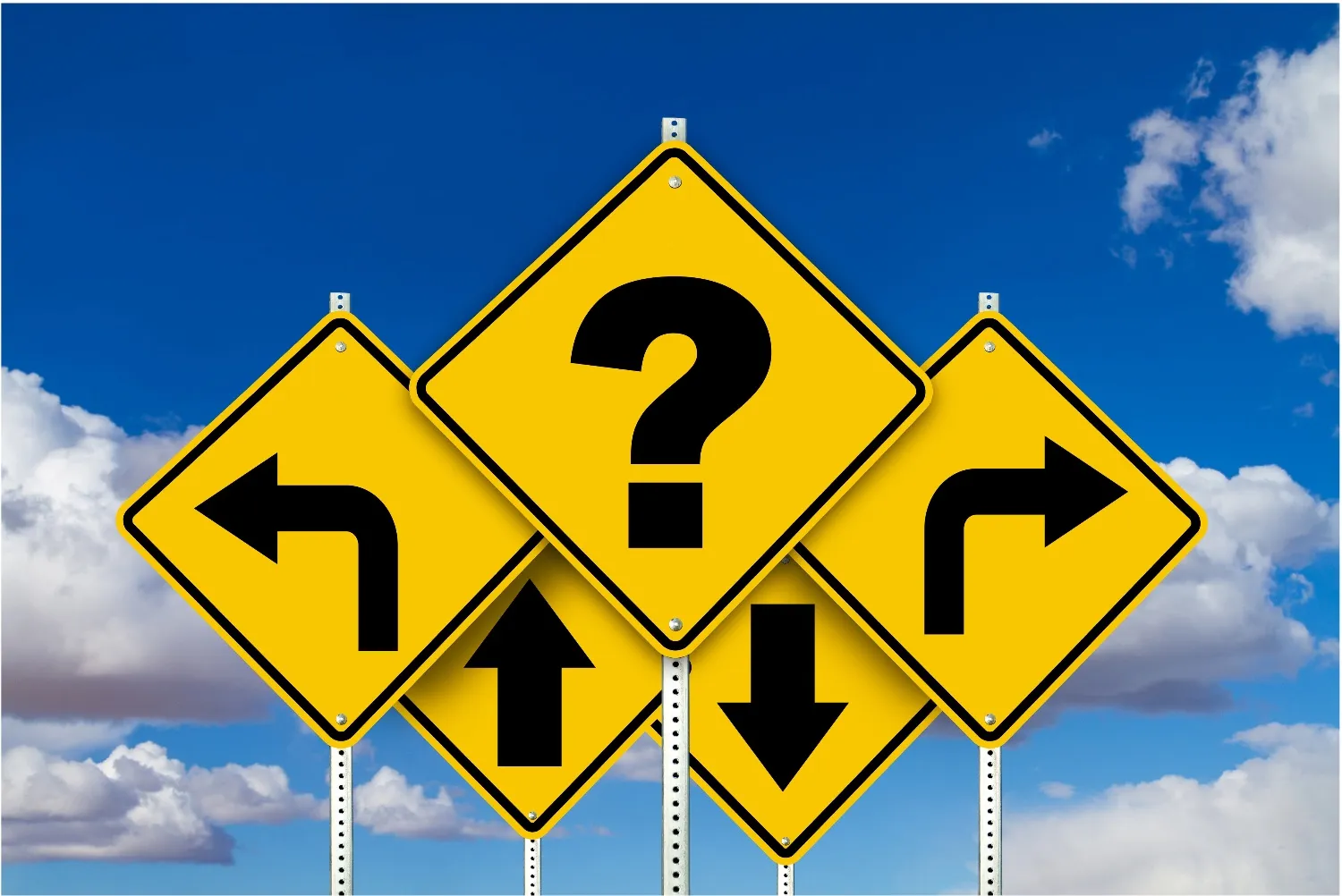 Five yellow road signs against a blue sky, arrows pointing left, right, up and down around a question mark