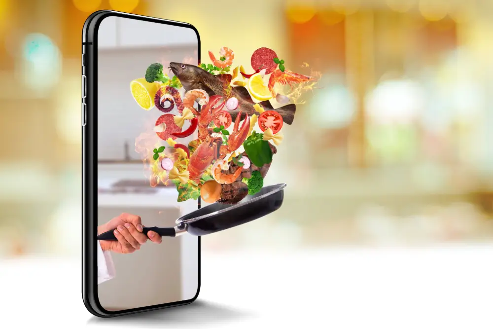 A hand reaching out of a phone screen with a frying pan, seafood and vegetables flying from it
